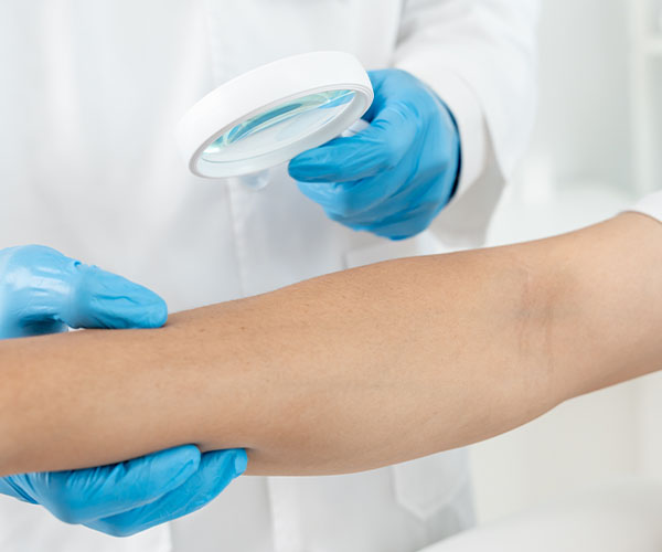 General practitioner inspecting patient's arm